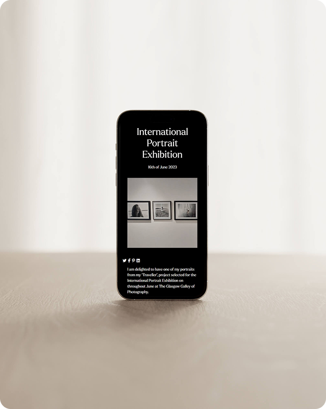 Phone mockup displaying a photographer's portfolio website announcing an exhibition